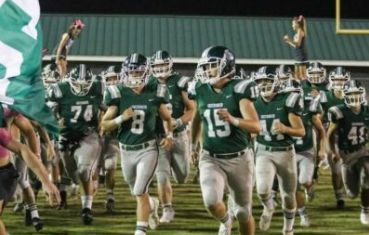 Bobcats run through the banner before kickoff